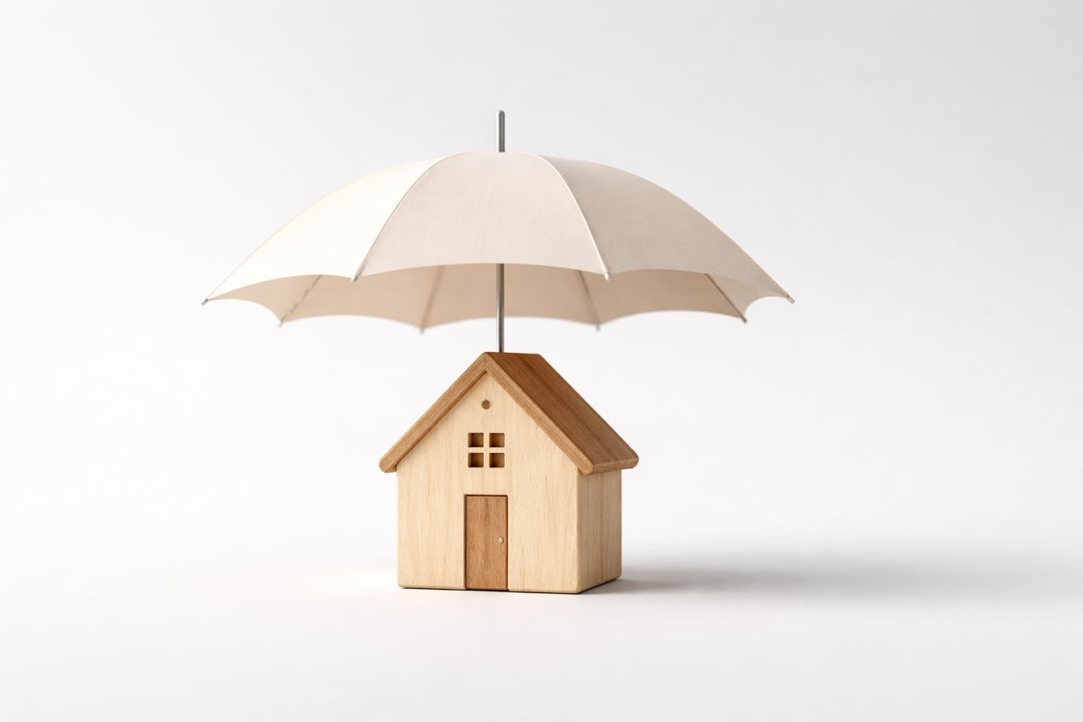 Ubezpieczenie budowy domu - ochrona inwestycji Mały parasol chroniący model domu - metafora ubezpieczenia budowy